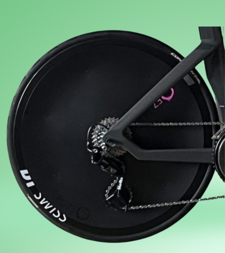 Black aerodynamic triathlon disc rear wheel with drivetrain and chain on a racing bike.