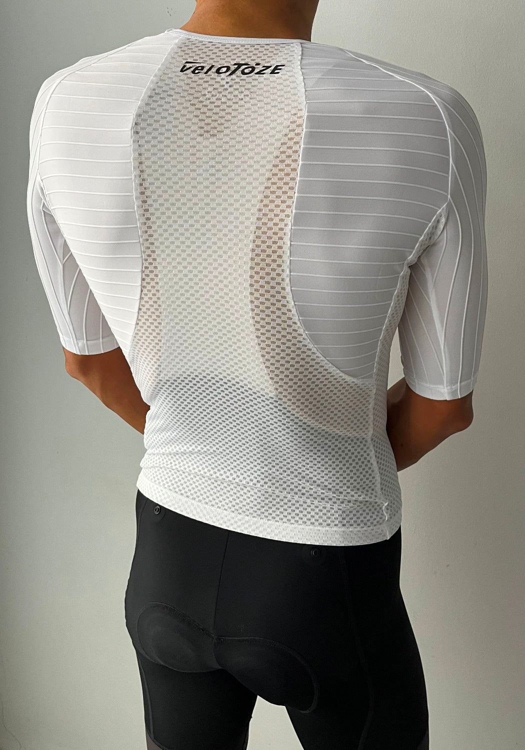Cyclist wearing a white mesh cycling base layer and black padded cycling shorts