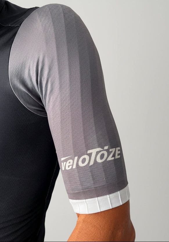 Close-up of cyclist wearing aerodynamic short sleeve grey jersey with veloToze logo
