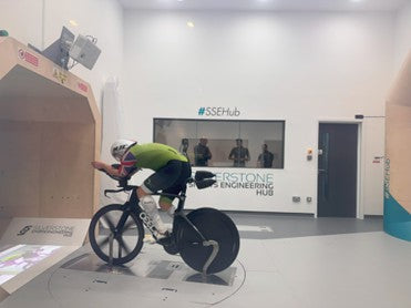 Triathlete performing an aerodynamic wind tunnel test on a racing bike.