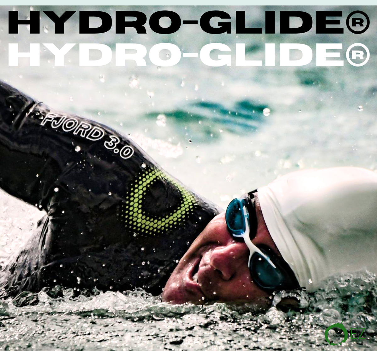 Triathlete swimming in open water wearing a black Fjord 3.0 wetsuit and white swim cap.