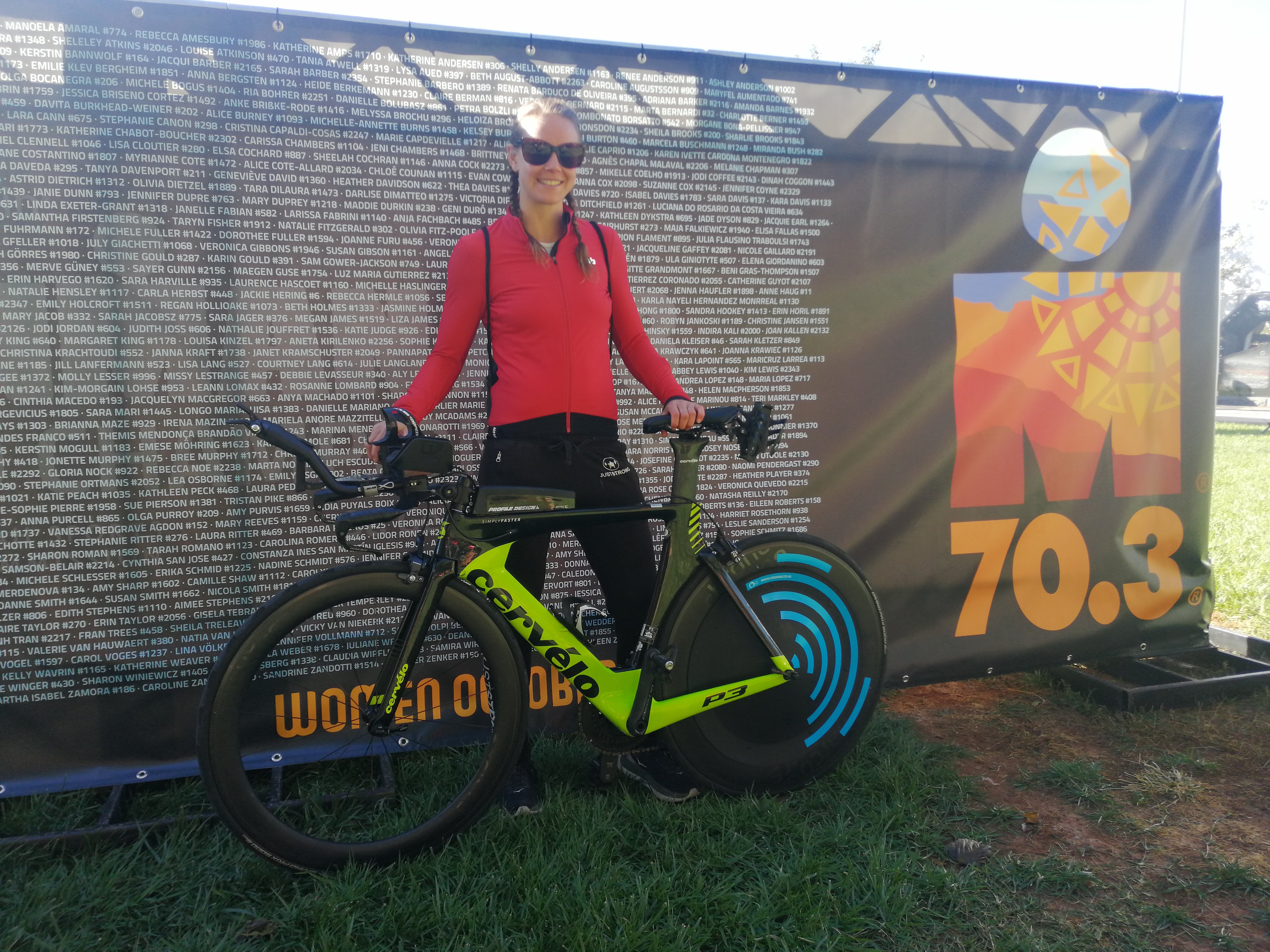 Female athlete with a Cervélo triathlon bike featuring a blue aerodynamic disc wheel cover.