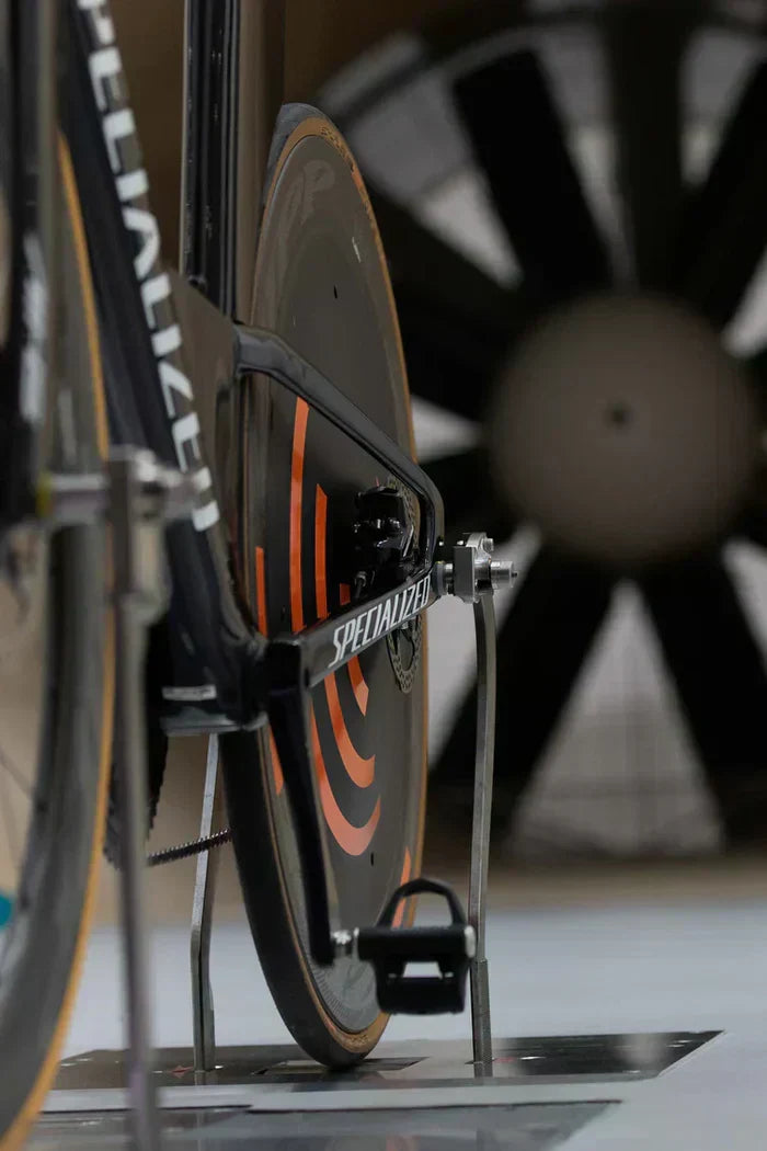 Specialized triathlon bike with aerodynamic disc wheel and chainring guard.