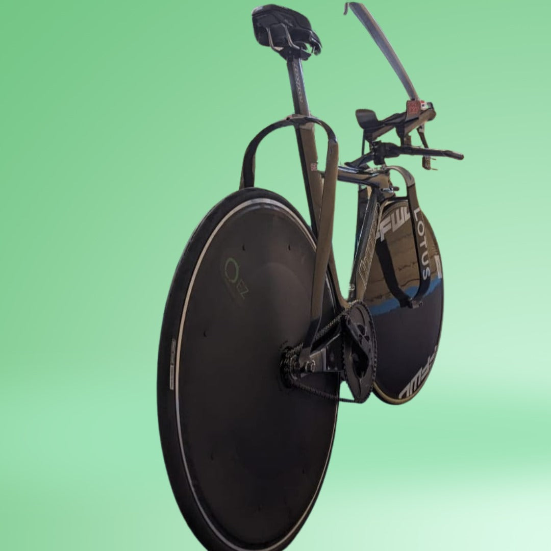 Aerodynamic triathlon bike with black disc wheel covers on a green background