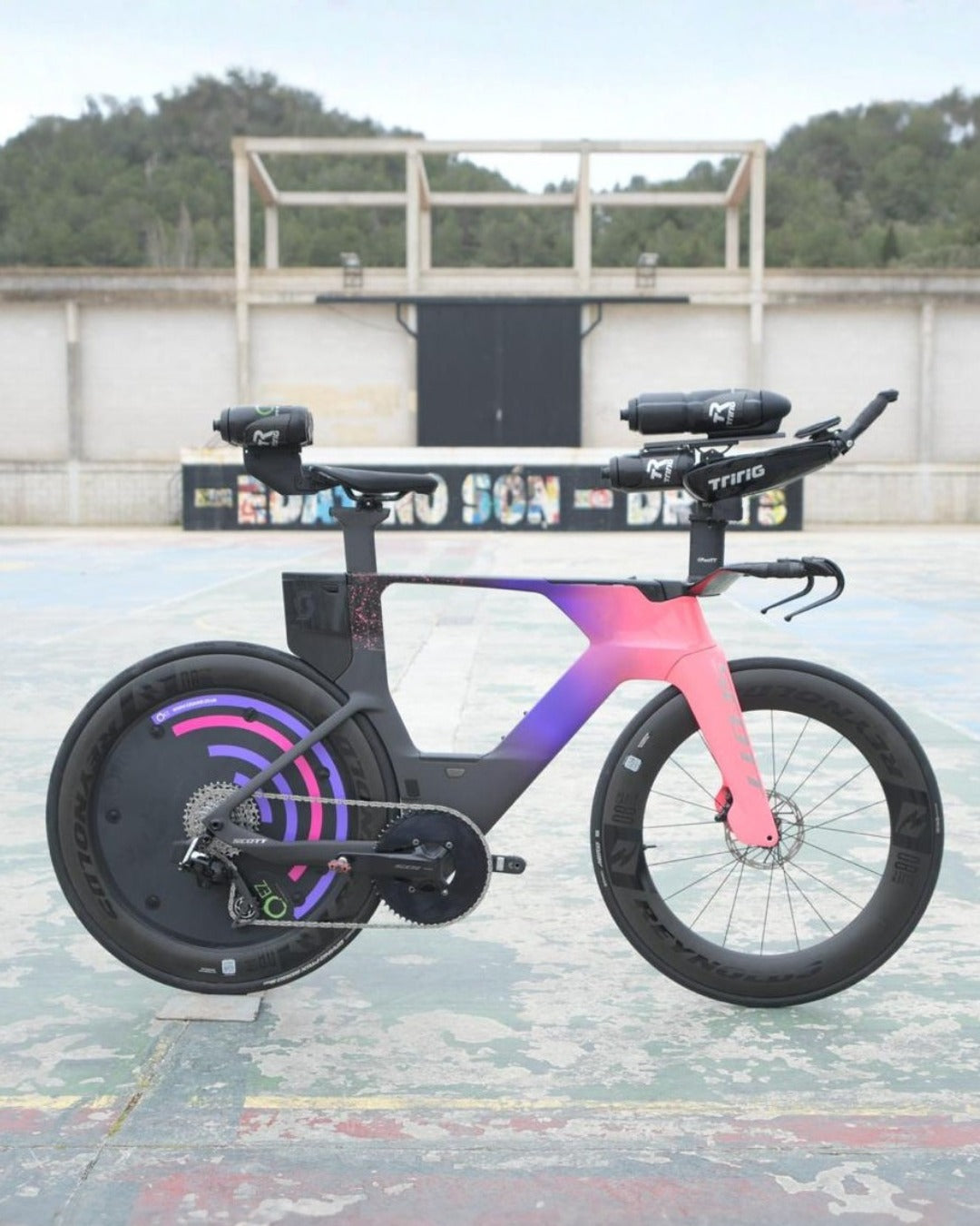 Aerodynamic triathlon bike with disc rear wheel and pink gradient frame