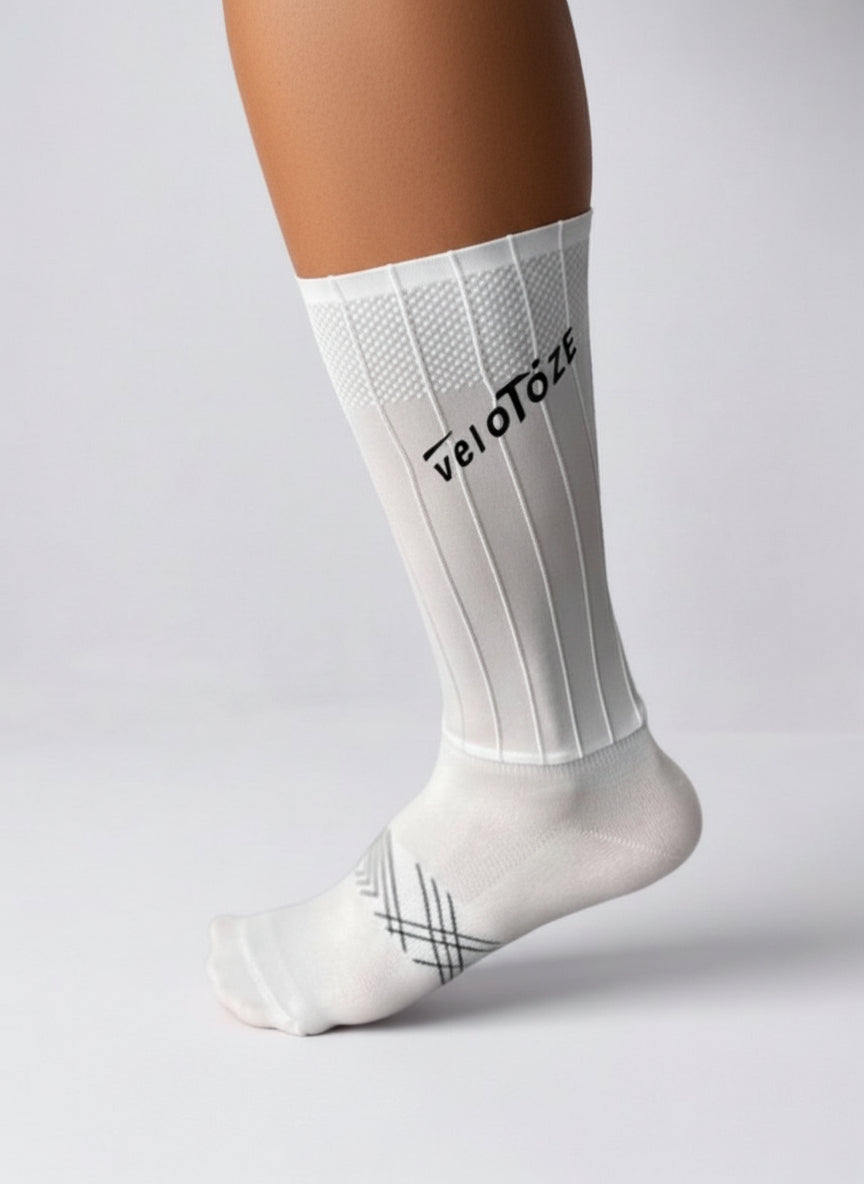 White cycling sock with ribbed texture and veloToze logo, modeled on a leg