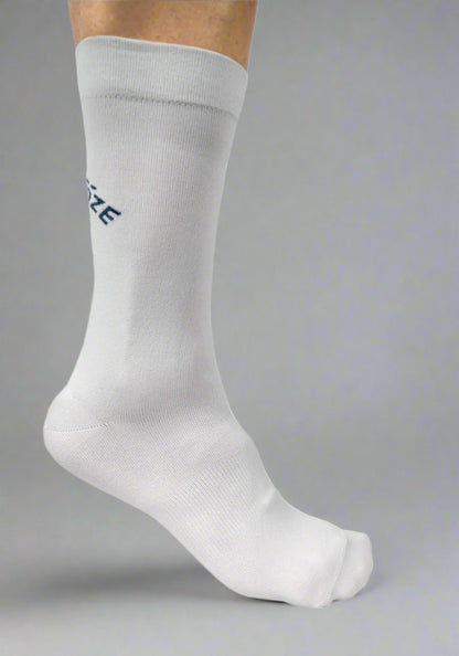 White cycling sock on foot against gray background, showing clean, minimalist design