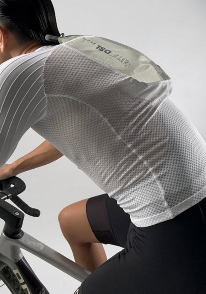 Cyclist in mesh jersey and black shorts riding bike, hydration pack visible on back