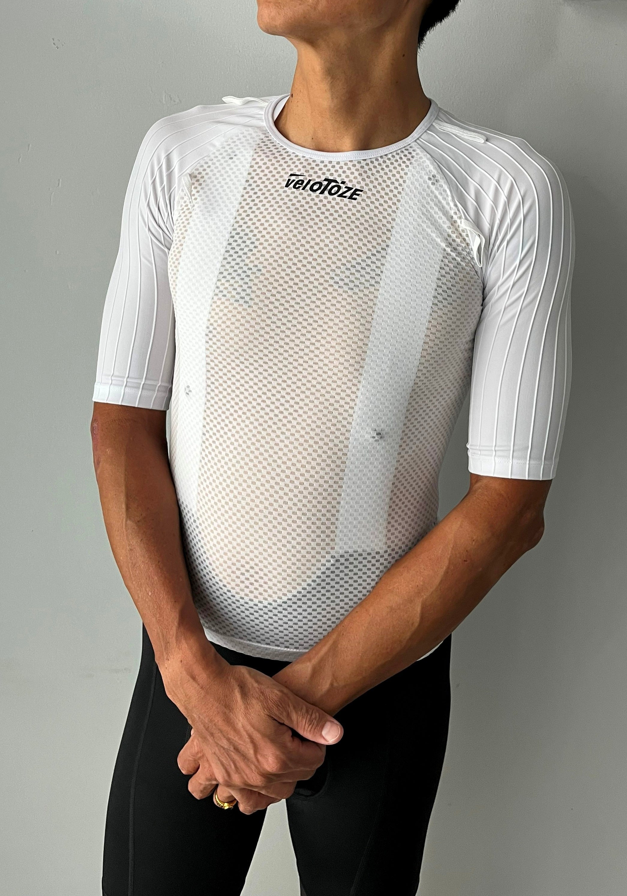 Man wearing a white mesh short sleeve cycling base layer shirt and black cycling shorts